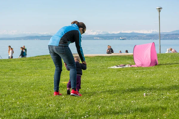 Carina bambina imparare a camminare con sua madre in un parco . — Foto Stock