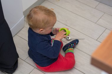 Kiremit döşemede oturan bir çocuğun görüntüsünü alçaltın.