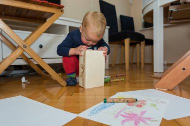 Çizim ve çeşitli kalemlerle yerde uzanmış çocuk oyun odası.