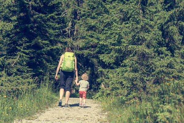 Caminhadas de mãe e filha em um caminho florestal . — Fotografia de Stock