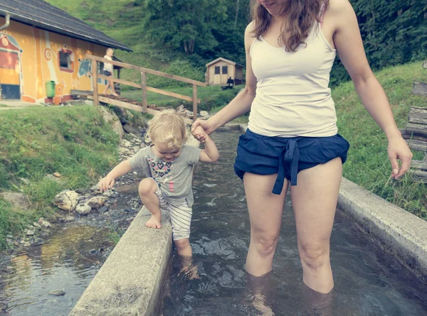 Mãe e filha se divertindo andando através do tanque de água no parque infantil ao ar livre . — Fotografia de Stock