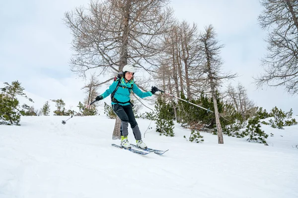 Kobieta narciarz korzystających z tyłu kraju narciarstwo w górach. — Zdjęcie stockowe