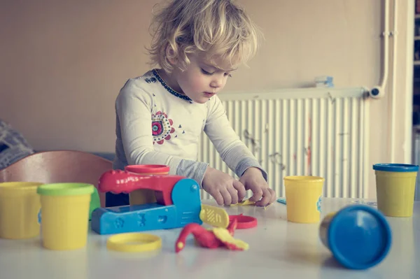 Roztomilé dívka hraje s mnoha barevnými těsta. — Stock fotografie