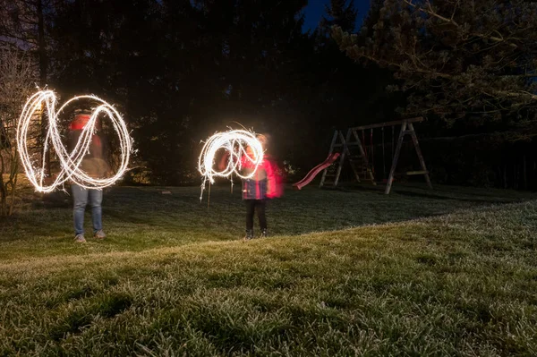 Child light painitng with christmas sparklers outside. — Stock Photo, Image