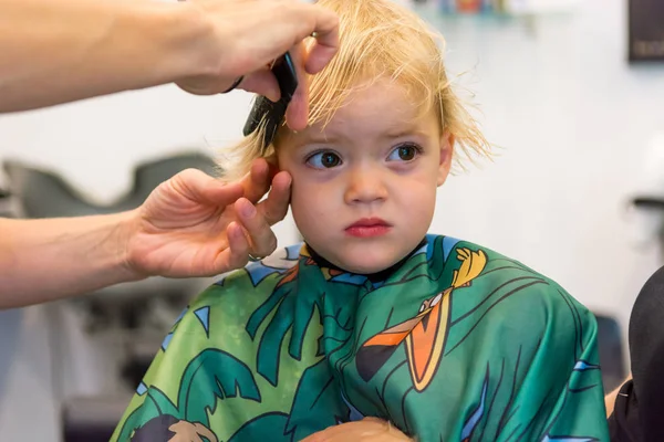 Cute blonde girl having her first haircut. — ストック写真