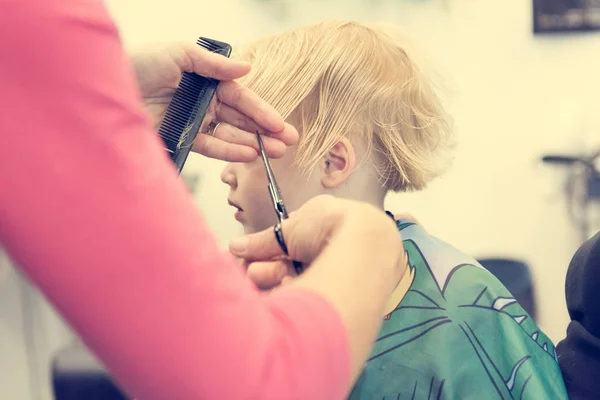 Cute blonde girl having her first haircut. — ストック写真