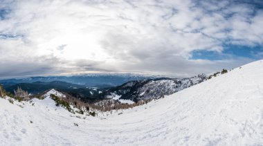 Gökyüzü bulutlu dağların muhteşem kış panoramik manzarası.