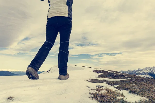 Nízký úhel pohledu na osobu kráčející po zasněženém hřebeni hory. — Stock fotografie