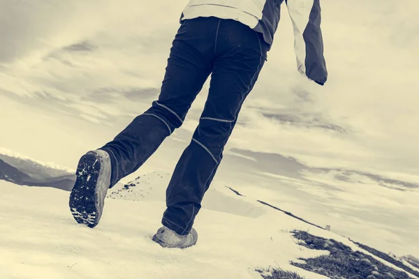 Vista de ângulo baixo da pessoa que anda na montanha coberta de neve . — Fotografia de Stock