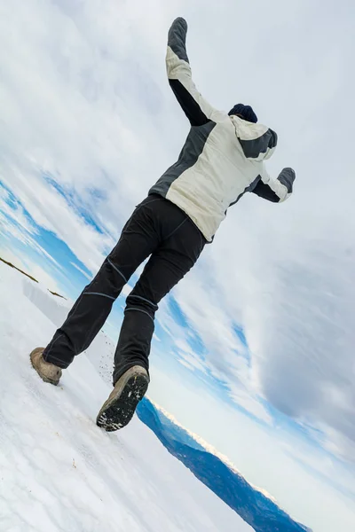 Karla kaplı dağ sırtında yürüyen kişinin alçak açılı görüntüsü. — Stok fotoğraf