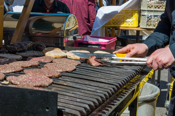 Dettaglio dello chef che prepara deliziosi hamburger sul barbecue all'aperto . — Foto Stock