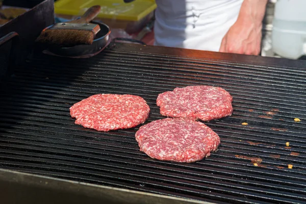 Dettaglio dello chef che prepara deliziosi hamburger sul barbecue all'aperto . — Foto Stock