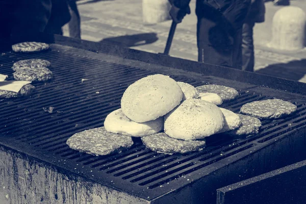 Dettaglio dello chef che prepara deliziosi hamburger sul barbecue all'aperto . — Foto Stock