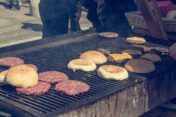 Dettaglio dello chef che prepara deliziosi hamburger sul barbecue all'aperto . — Foto Stock