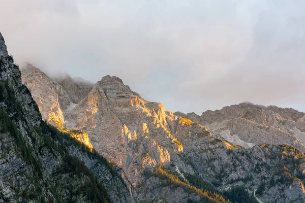 Sol da manhã iluminando um vale exuberante da montanha . — Fotografia de Stock