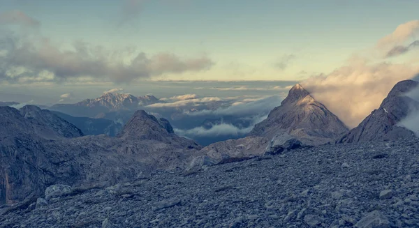 Pandangan gunung yang spektakuler dengan awan malam bergulir di atas puncak dan pegunungan . — Stok Foto