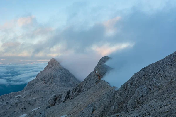 Захватывающий вид на горы с вечерними облаками, катящимися над вершинами и хребтами . — стоковое фото