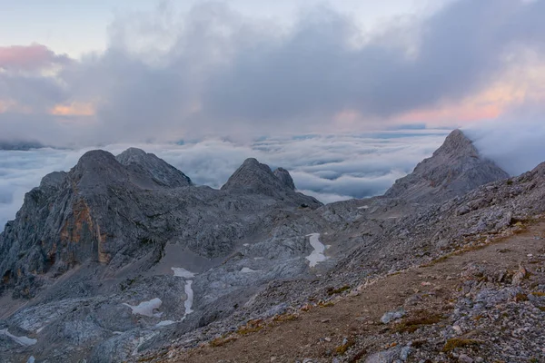 Spektakulärer Bergblick mit Abendwolken, die über Gipfel und Bergrücken rollen. — Stockfoto