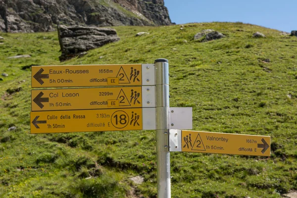 Señal amarilla que indica diferentes rutas de senderismo por encima del área de Valnontey . — Foto de Stock