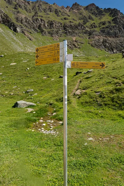 Yellow sign post indicating different hiking trails above Valnontey area. — Stock Photo, Image