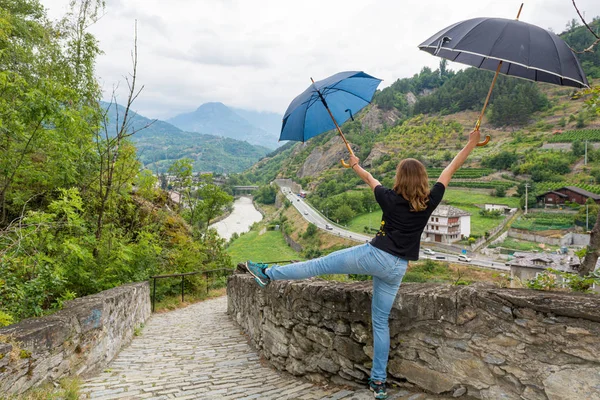 Yağmurda dans eden genç bir kadın bir çift şemsiye kullanıyor.. — Stok fotoğraf