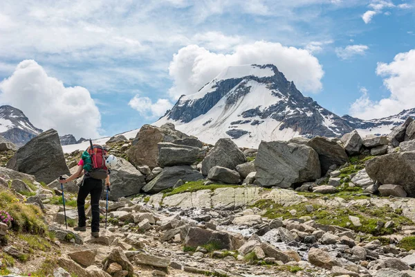 壮大な山の景色に囲まれた石の歩道上の女性トレッカー. — ストック写真