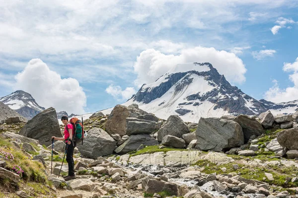 壮大な山の景色に囲まれた石の歩道上の女性トレッカー. — ストック写真