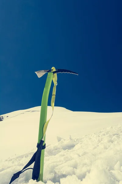 Mountan tema vista de machado de gelo verde colocado na neve . — Fotografia de Stock