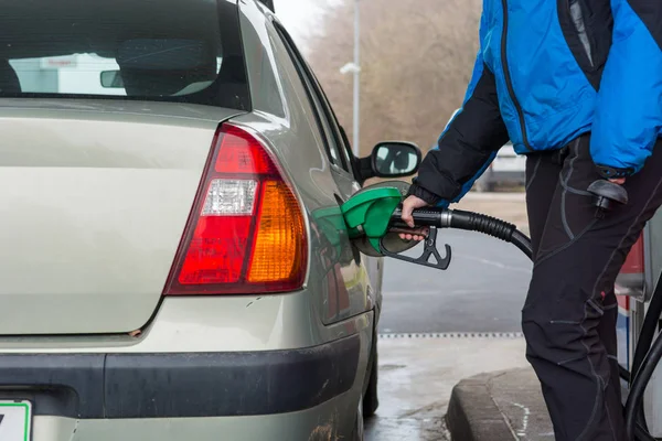 Detail view of hand holding fuel nozzle at petrol station. — Stock Photo, Image