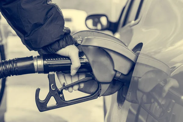 Detail view of hand holding fuel nozzle at petrol station. — Stock Photo, Image