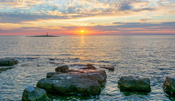 Oceán východ slunce s malým majákem na ostrově. — Stock fotografie