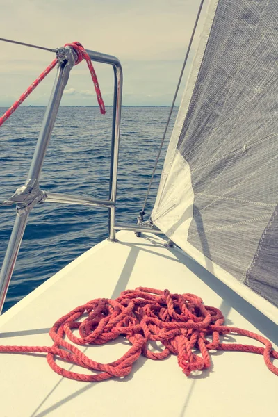 Segelbåt däck med staplade röda rep under segling. — Stockfoto