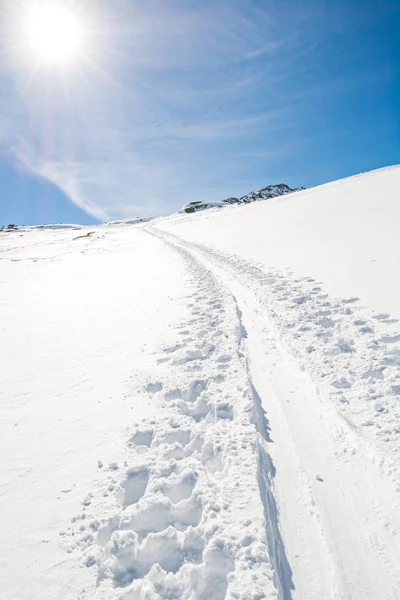 スキートレイルが斜面を登る壮大な冬の山の景色. — ストック写真