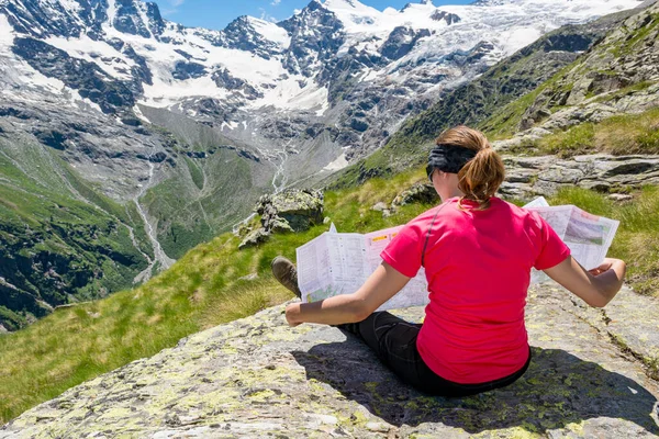 Morena atraente segurando um mapa e planejando onde caminhar . — Fotografia de Stock