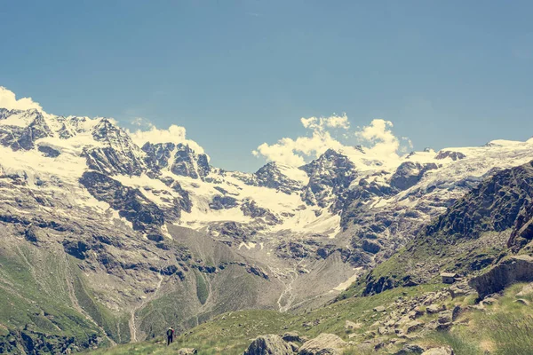Spektakularna panorama gór ze szczytami i zboczami pokrytymi lodowcami nad bujną zieloną doliną. — Zdjęcie stockowe