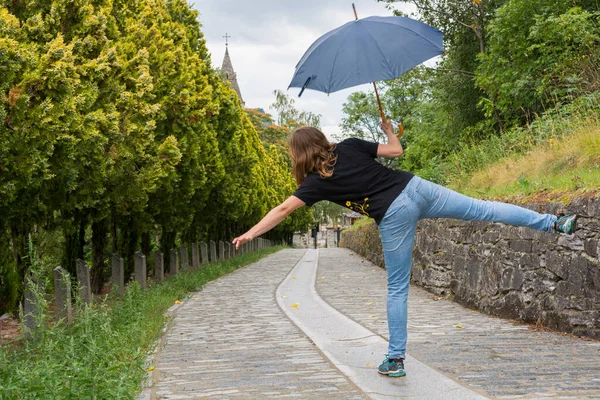 Jovem dança feminina na chuva usando guarda-chuva . — Fotografia de Stock