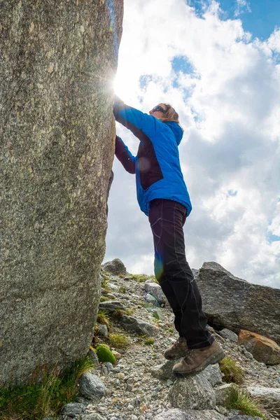 Female mountaineer practicing boulder climbing outdoor on large boulder. — ストック写真