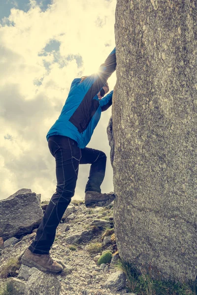 Female mountaineer practicing boulder climbing outdoor on large boulder. — 图库照片