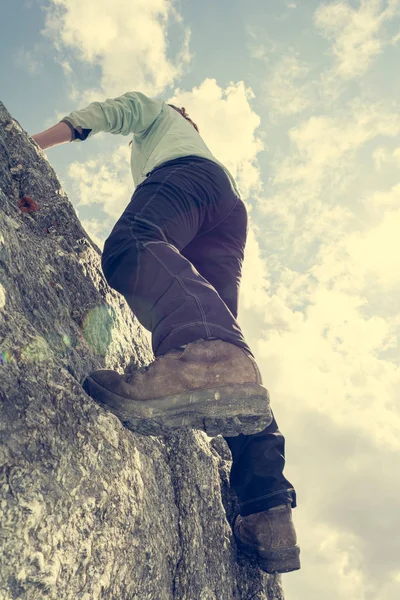 Female mountaineer practicing boulder climbing outdoor on large boulder. — ストック写真