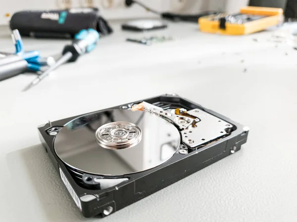 Opened computer hard drive on a table prepared to be fixed. — Stockfoto