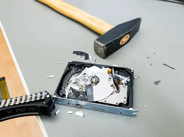 Destroying computer hard drive with a hammer.