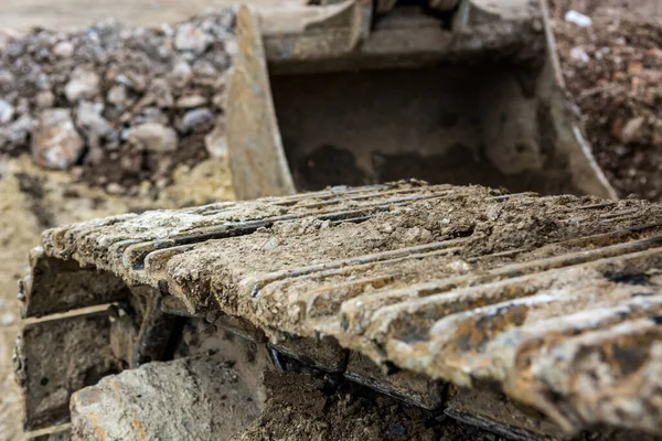 Faixas de uma máquina escavadora em um canteiro de obras . — Fotografia de Stock