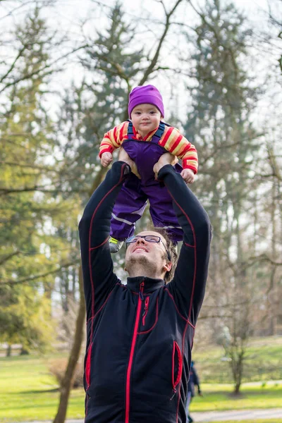Pai feliz brincando com sua filha bebê em um parque . — Fotografia de Stock