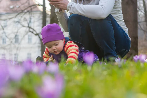 Mãe e filha posando com flores no prado da primavera . — Fotografia de Stock