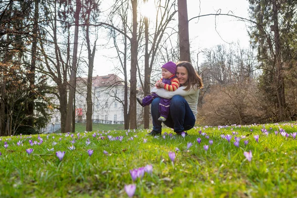 Mãe e filha posando com flores no prado da primavera . — Fotografia de Stock
