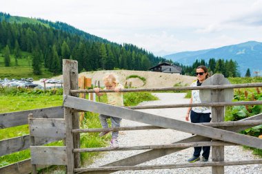 Dağdaki çitlerden tırmanan tatlı sarışın kız..