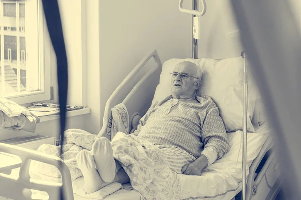 Älterer Mann liegt im Krankenhaus auf einem Bett. — Stockfoto