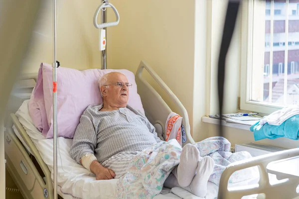 Älterer Mann liegt im Krankenhaus auf einem Bett. — Stockfoto