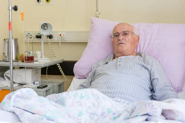 Älterer Mann liegt im Krankenhaus auf einem Bett. — Stockfoto