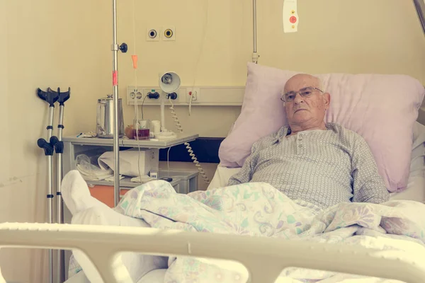 Älterer Mann liegt im Krankenhaus auf einem Bett. — Stockfoto